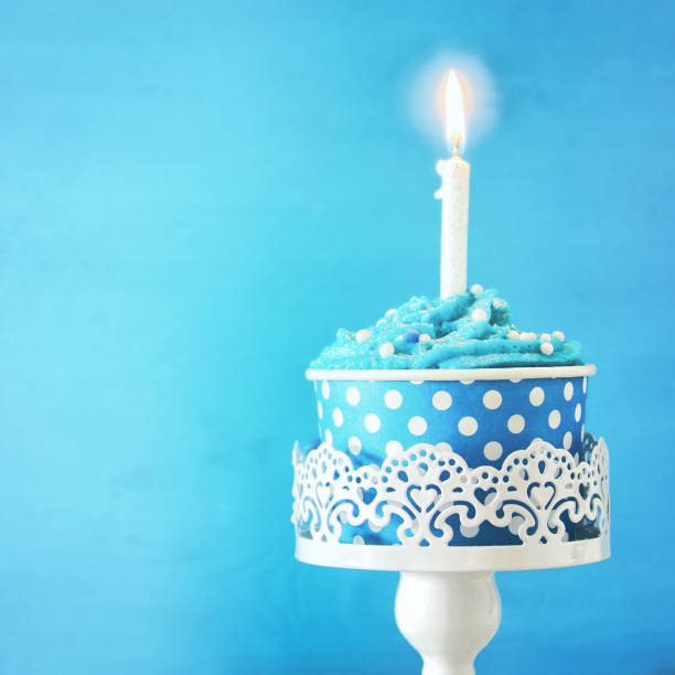 istock Birthday concept with cupcake and one candle on wooden table 821723914