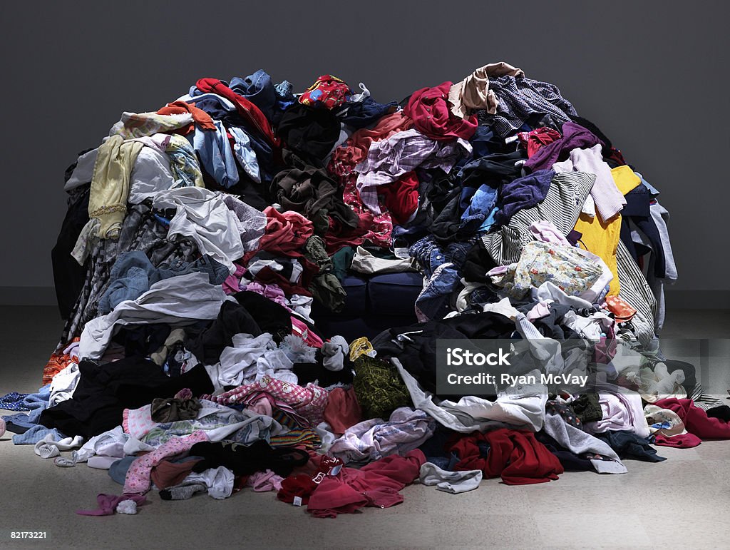 Sofa buried under piles of clothes  Clothing Stock Photo