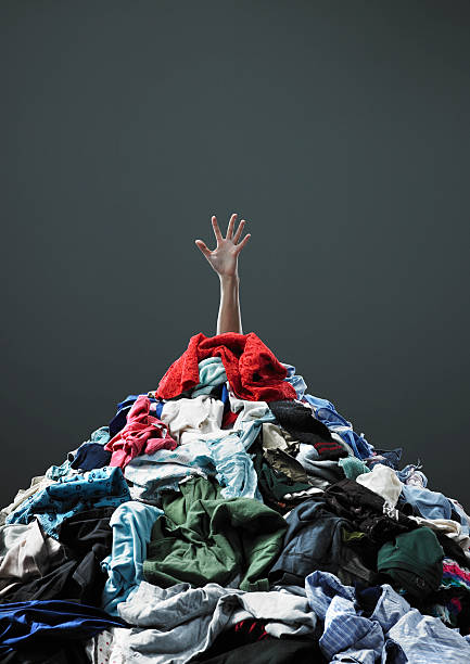 Hand coming out of pile of clothing  unknown gender stock pictures, royalty-free photos & images