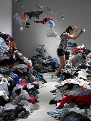 A room cluttered with piles of clothes