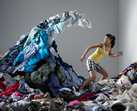 Woman underneath wave of laundry