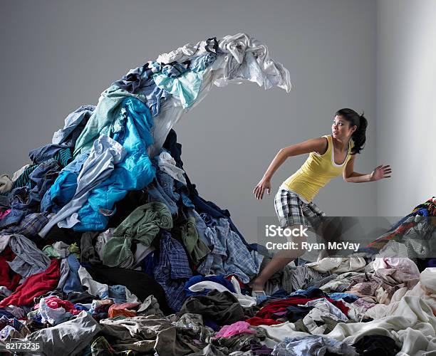 Woman Underneath Wave Of Laundry Stock Photo - Download Image Now - Laundry, Organization, Heap