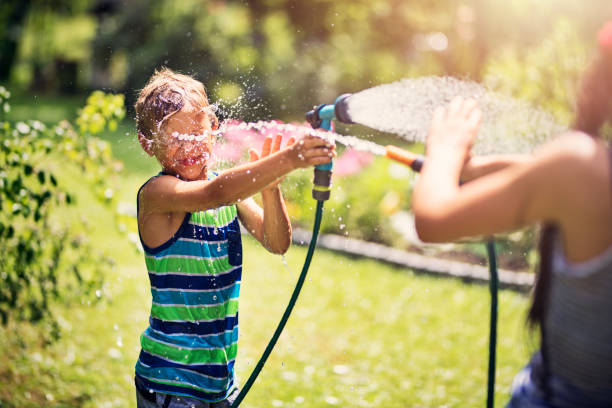 istock Children having garden hose fun in back yard 821734672
