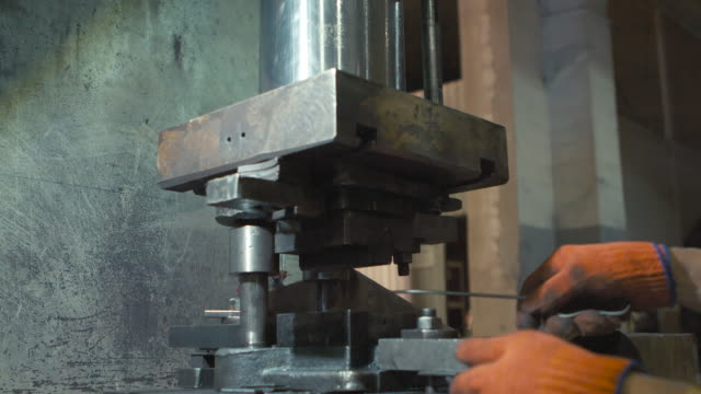 The machine cuts the sheet metal. Large hydraulic guillotine shears.