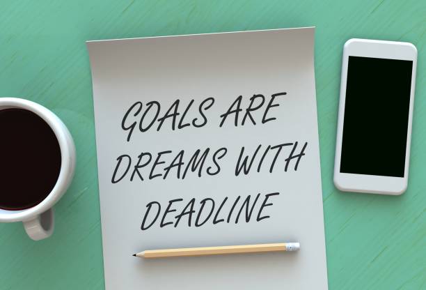 istock Goals Are Dreams With Deadline, message on paper, smart phone and coffee on table, 3D rendering 821738740