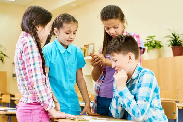 Photo of Girls Talking to one Boy in School