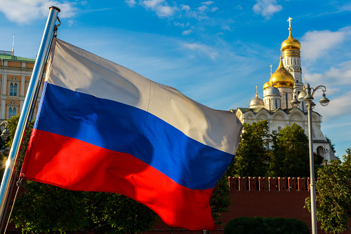 Russian flag on the background of the Kremlin, Archangel Cathedral in the Moscow Kremlin.