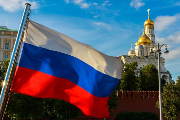 Photo of Russian flag on the background of the Kremlin, Archangel Cathedral in the Moscow Kremlin.