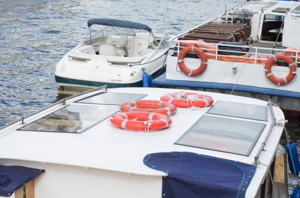 River buses with lifebuoys on the roof and the sides are moored to the pier