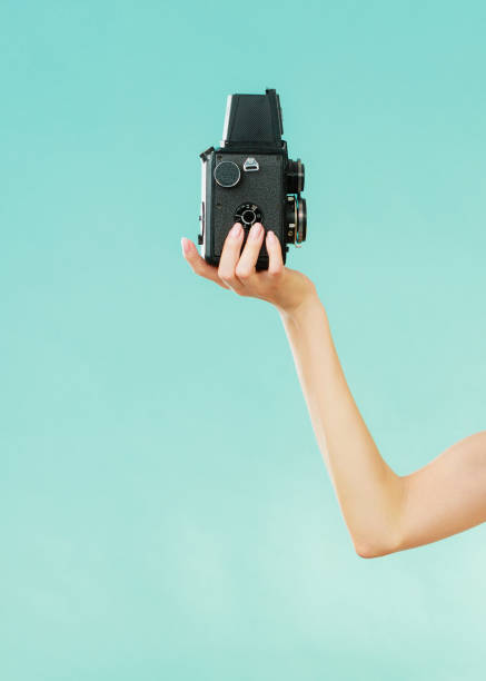 istock woman holds old camera on blue 821759016
