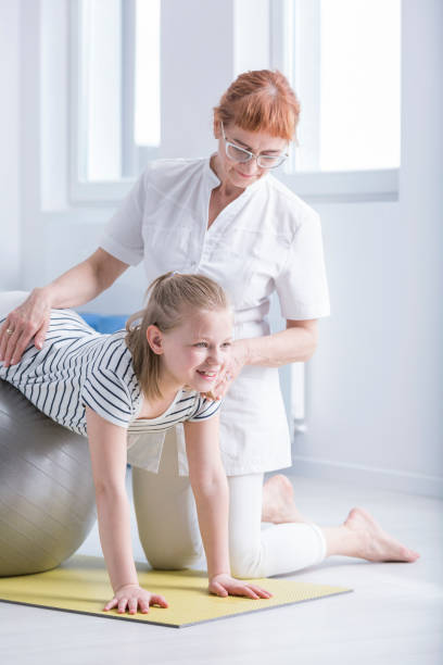 istock Physiotherapist supporting girl with scoliosis 821759344