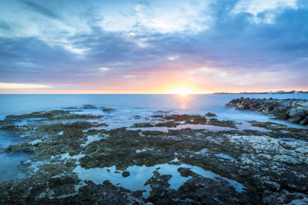 istock Tropical sunset with ocean and corals on foreground 821761406