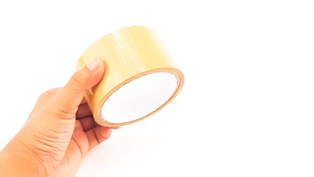 istock Man hand holding thick brown plastic tape with big core 821765530