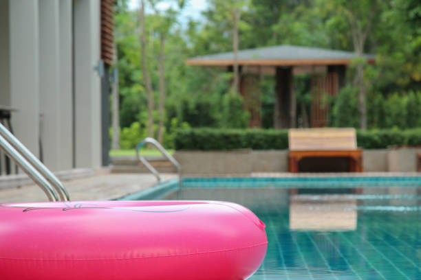 tubo da bagno rosa e sfondo sfocatura piscina - swimming tube inflatable circle foto e immagini stock
