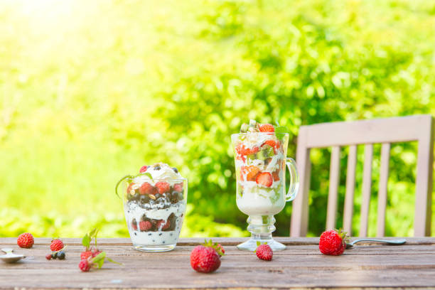 istock Layered dessert with raspberry, strawberry, black currant and kiwi, cream and biscuits in glasses 821772882