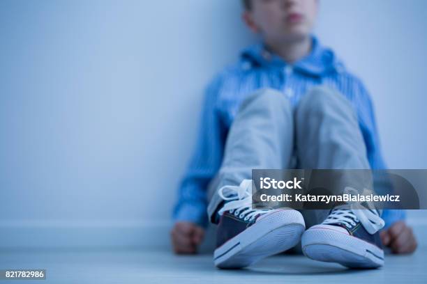 Boy Sitting On A Floor Stock Photo - Download Image Now - Child, Autism, Depression - Sadness