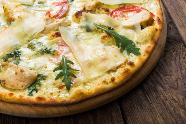 istock Delicious pizza with chicken, parmesan and fresh arugula 821783282