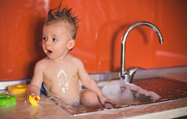 istock Cute Baby taking a bath in Kitchen Sink 821786840