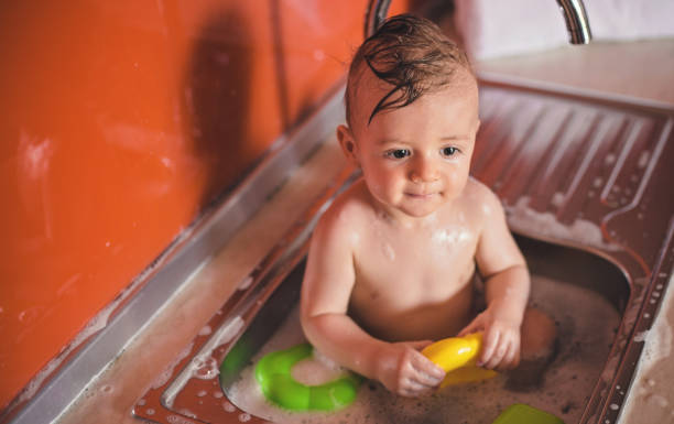 istock Adorable Baby boy in kitchen sink 821787316
