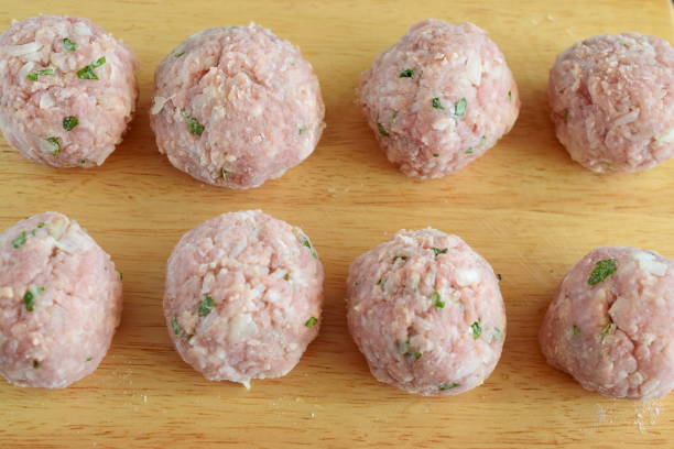 istock Raw beef meatballs with mint and rice on a wooden cutting board. Step by step cooking. Traditional greek food 821804246