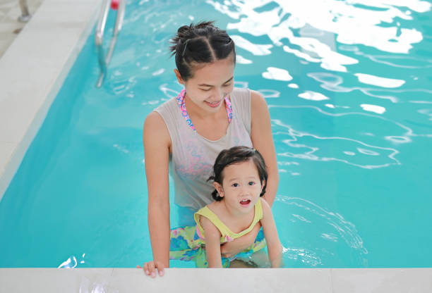 istock Close up mother teaching kid in swimming pool. 821807282