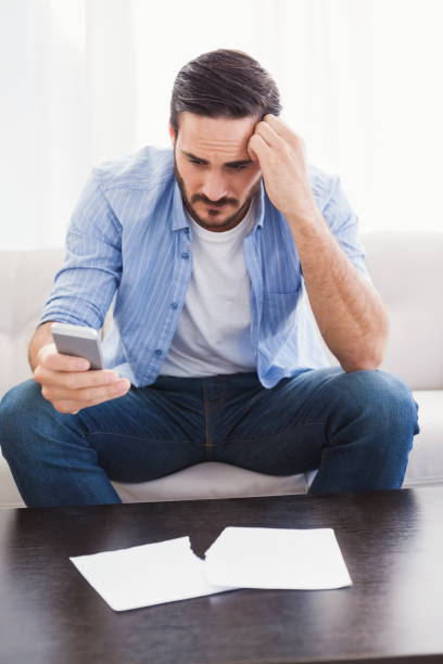 istock Worried man holding his phone 821812378