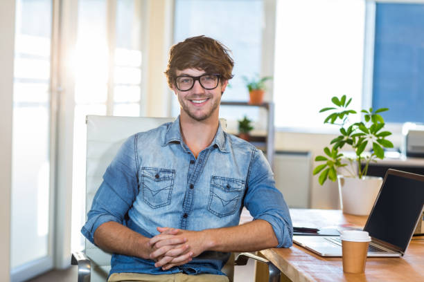 istock Smiling casual businessman sitting at desk 821815092