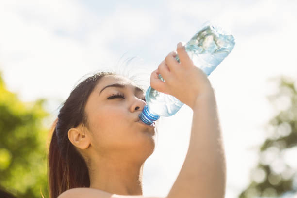 istock Healthy woman drinking water in park 821815382
