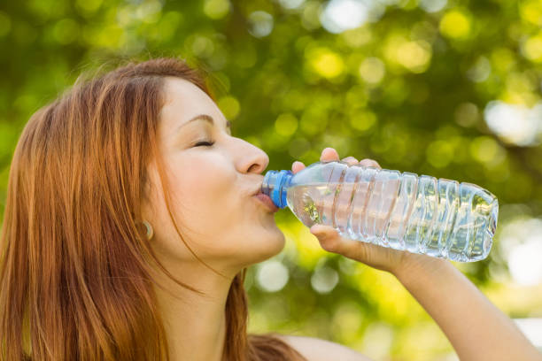 istock Pretty redhead drinking water in park 821815440