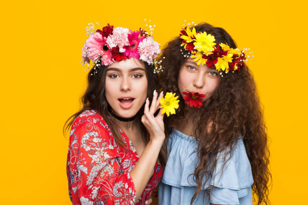 istock Two smiling girls posing with flowers 821816242