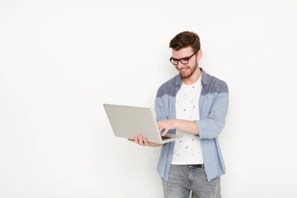 istock Young man standing with laptop 821818786
