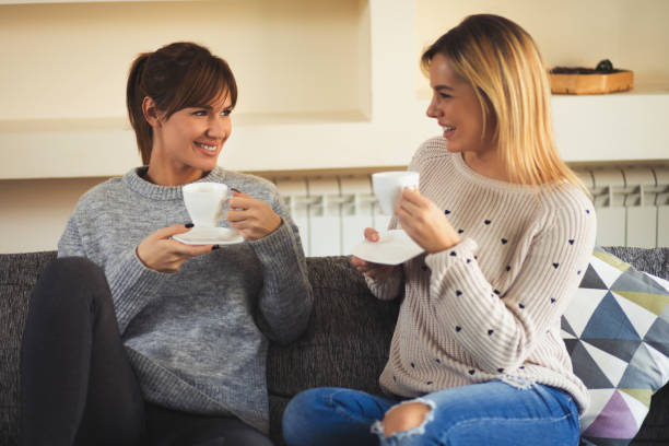 istock Two young cheerful female friends enjoying coffee and conversation 821819024