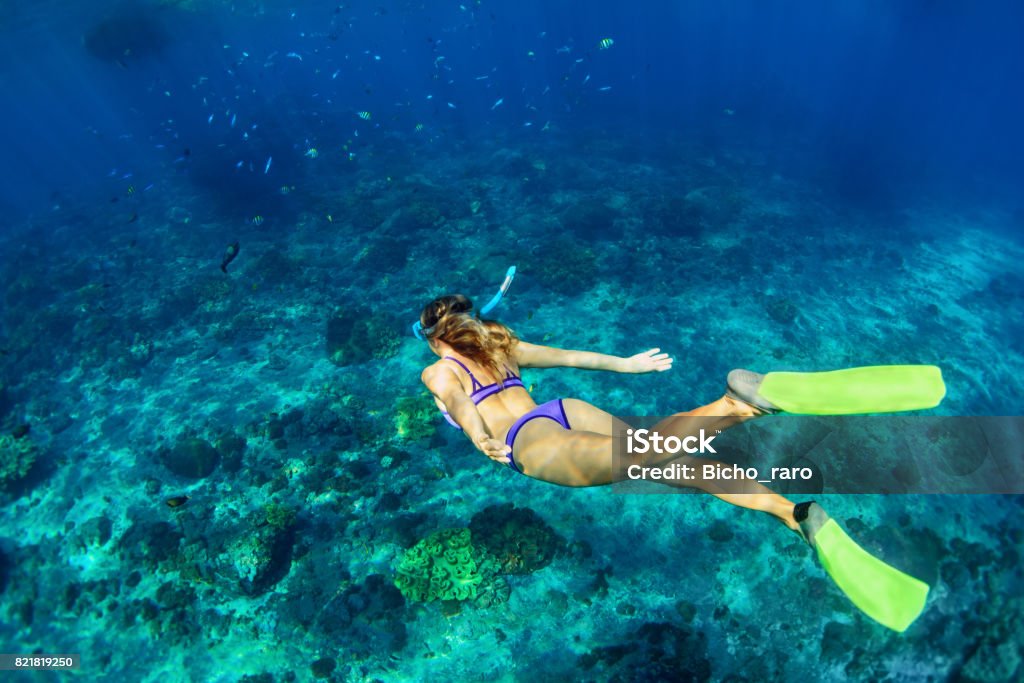 Young woman diving underwater Happy family - girl in snorkeling mask dive underwater with tropical fishes in coral reef sea pool. Travel lifestyle, water sport outdoor adventure, swimming lessons on summer beach holiday with kids Snorkeling Stock Photo