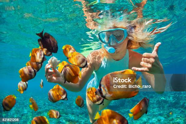 Mujer Joven Snorkeling Con Peces De Arrecife De Coral Foto de stock y más banco de imágenes de Buceo con tubo