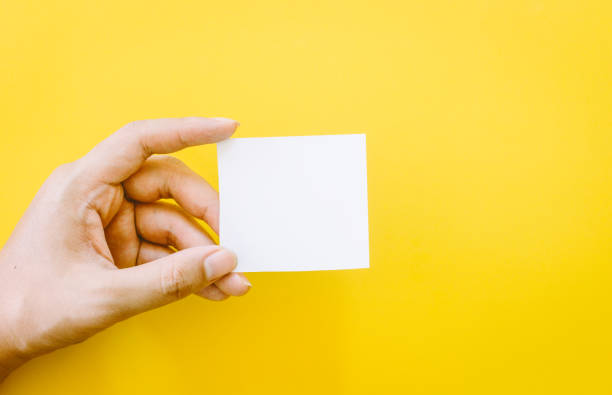 istock Hand holding paper on yellow background 821821280