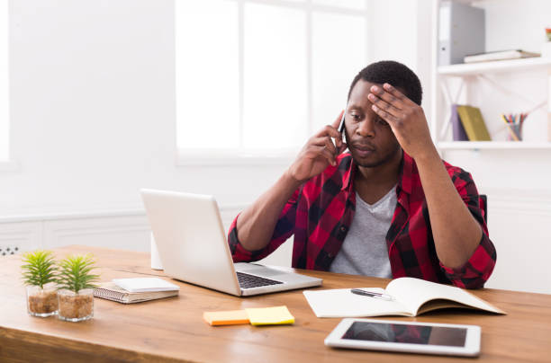 istock Young black businessman call mobile phone in modern white office 821824132