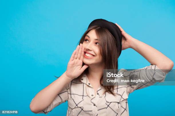 Trendy Girl Gossiping On Blue Background Stock Photo - Download Image Now - Adult, Adults Only, Announcement Message