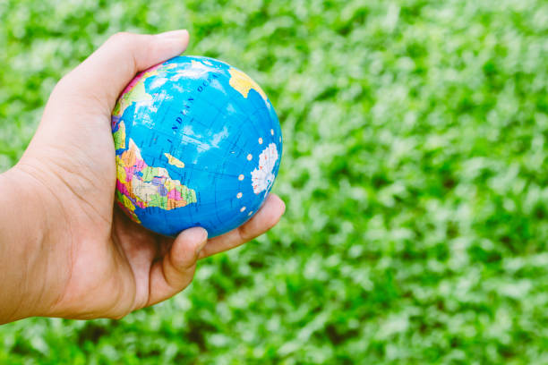 istock Hand holding model of the globe on green background 821825870