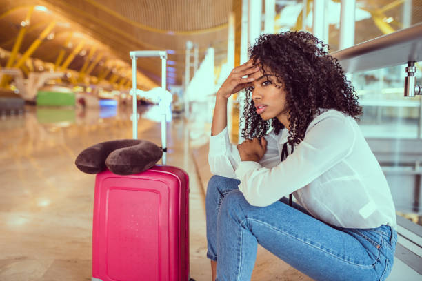 black Woman upset and frustrated at the airport with flight canceled stock photo