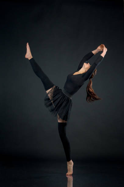 istock woman athlete gymnast performing acrobatic elements on a black background 821832378