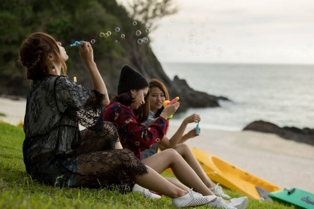 istock Young female having fun and blowing bubbles outdoors 821832394