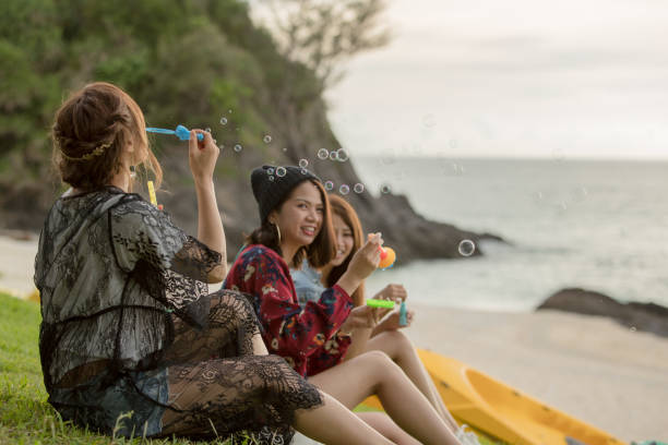 istock Young female having fun and blowing bubbles outdoors 821832470