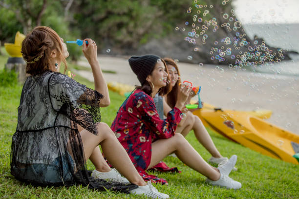 istock Young female having fun and blowing bubbles outdoors 821832520