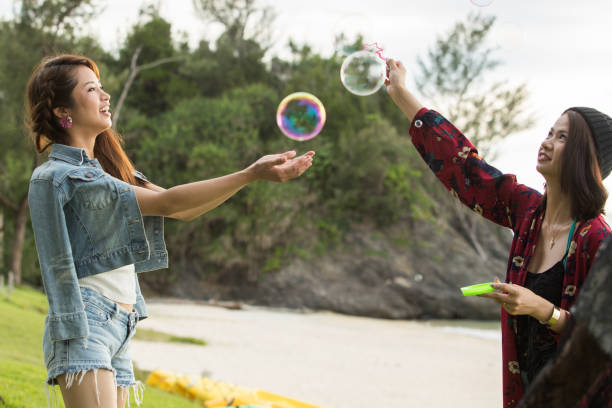 Young female having fun and blowing bubbles outdoors