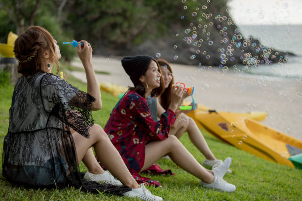 istock Young female having fun and blowing bubbles outdoors 821832530
