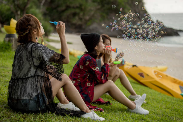 istock Young female having fun and blowing bubbles outdoors 821832540