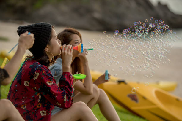 istock Young female having fun and blowing bubbles outdoors 821832596