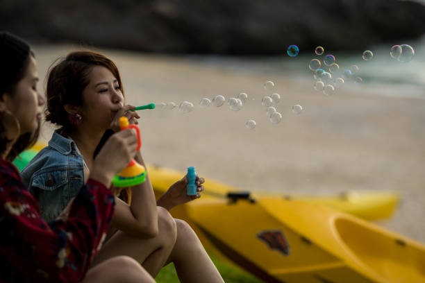 istock Young female having fun and blowing bubbles outdoors 821832604
