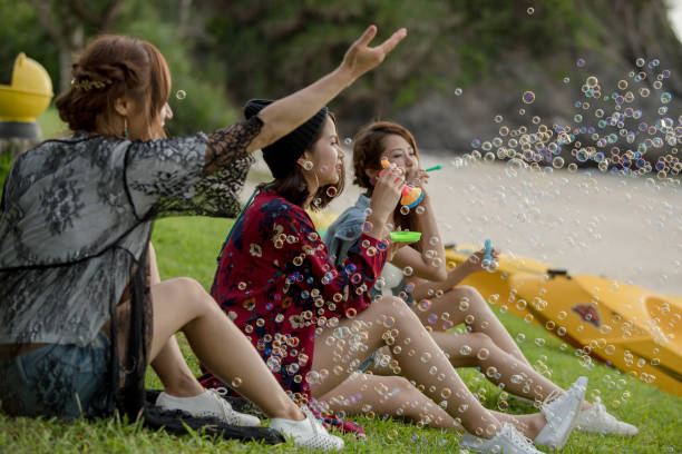 istock Young female having fun and blowing bubbles outdoors 821832624