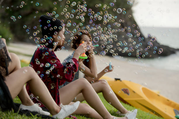 istock Young female having fun and blowing bubbles outdoors 821832630